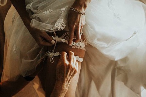 bride putting on her garter belt. Image by We Are The Cashmans