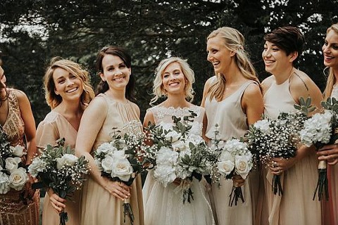 Bridal party is light pink and gold mismatched bridesmaids dresses.